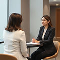 woman in a business suit talking to anot