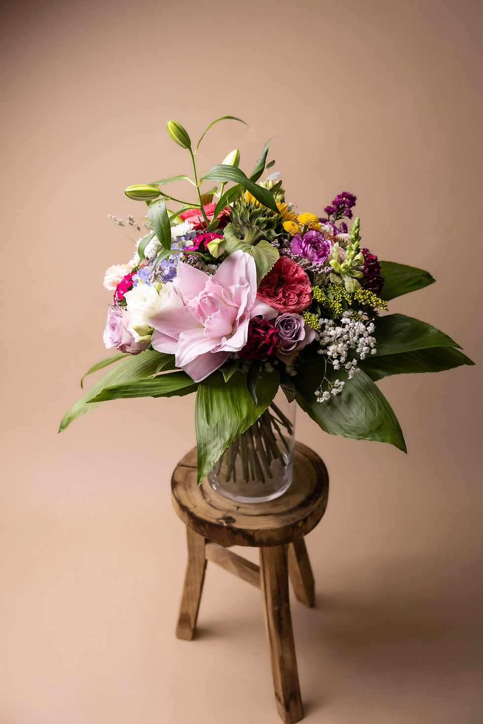bunter Blumenstrauß auf einem Holzhocker