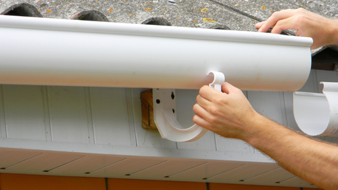 Man holding onto gutter 