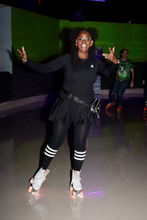 Skater striking a dynamic pose on the rink floor during family fun time at Castle Roller Skating.