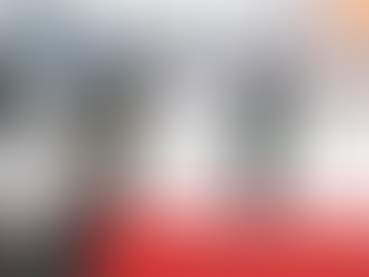 Three firefighters in full turnout gear and air tanks advance a hose line toward a large training fire outdoors while flames rise into the air. A fire engine is parked behind them as water sprays across the scene. A red banner at the bottom reads, “Thanksgiving Safety: Simple Steps to Keep Your Holiday Fire-Free,” alongside a “Step Up” firefighter recruitment graphic.