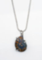 Polished ammonite pendant, set with three silver prongs