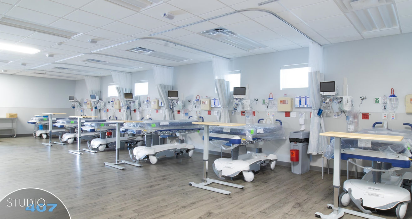 Bright, modern hospital room with multiple surgical beds and medical equipment.