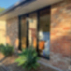 Black aluminium louvre windows set within a brick exterior
