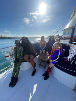 Halloween Kids 1-hour cruise aboard ÜberVida Bermuda on Saturday, October 31, 2026, featuring a fun superhero-themed afternoon with children in costumes, Halloween decorations, music, and family-friendly activities on the water.