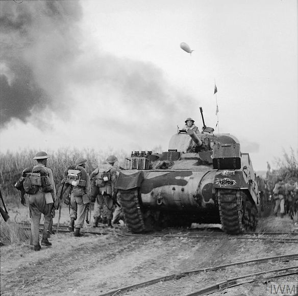 Un tanque Sherman y soldados de infantería avanzan por la carretera hacia Battipaglia dura