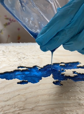 Pouring blue epoxy resin on a lake model of Lake Champlain