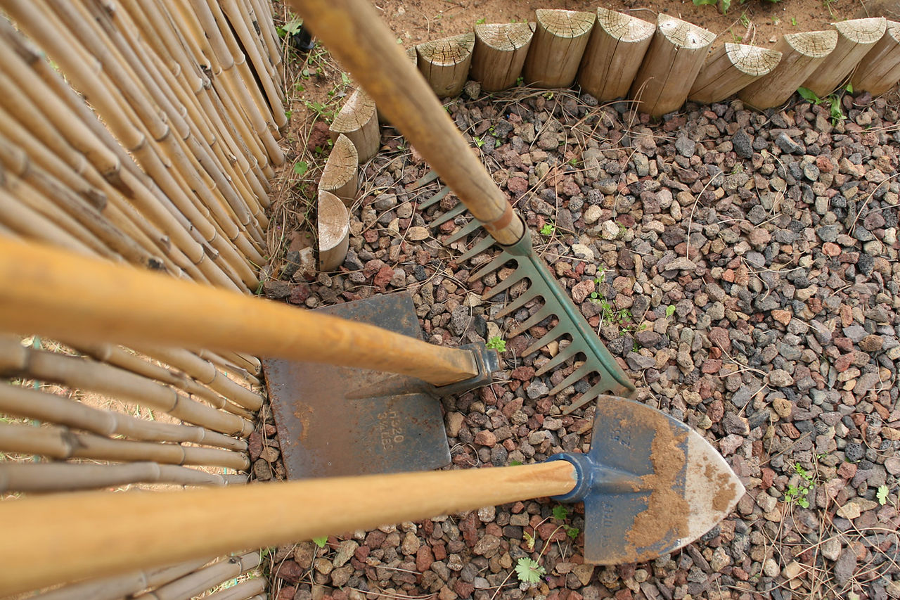 Traditional agricultural tools at Ein Yael. A wooden rake and shovels resting against a fence, used for farming the ancient stone terraces.