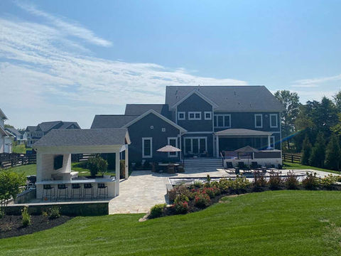 Large backyard with elevated hardscape, pool, and patio design.