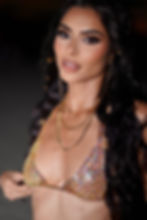 A close up picture of a beautfiul dark haired model wearing a colourful crystal bra