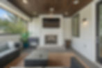 Luxury outdoor patio with fireplace, TV, and modern seating.