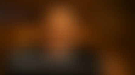 Veteran Bollywood actor Dharmendra smiles gracefully in a cinematic portrait, symbolizing his six-decade legacy and enduring charm at age 89, featured in an NFSTUBE tribute image.