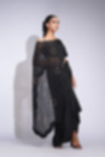 Model wearing black crepe dhoti-style draped skirt paired with a gold sequin embroidered organza cape by SHRUTI S