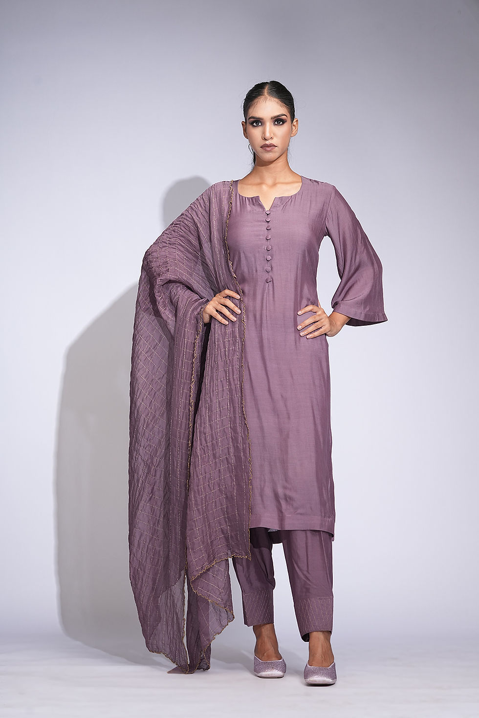 Thumbnail: Model wearing smoked purple cotton kurta set with bell sleeves, pleated salwar, and organza dupatta with zari checks