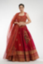 Model wearing dual-tone raw silk lehenga in plum and red with metallic hand block printed motifs in gold by SHRUTI S