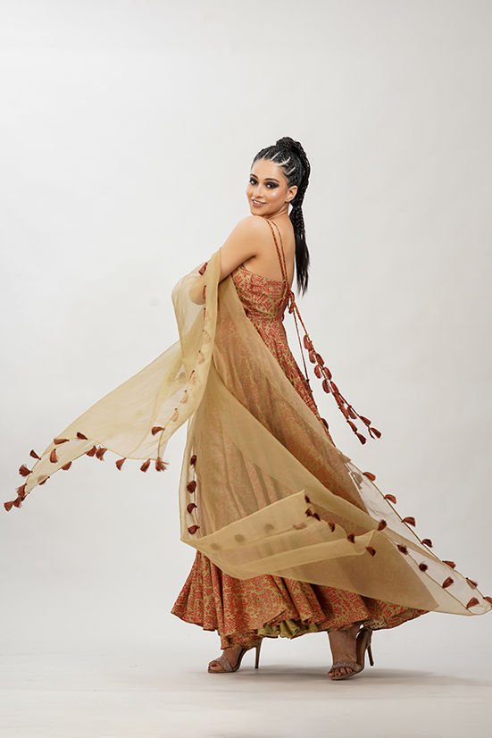 Gold silk anarkali with red hand block print, intricate red embroidery, and silk braids by SHRUTI S