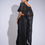 Thumbnail: Back view of model showing flowing organza cape and asymmetrical pleats on black drape skirt in motion.