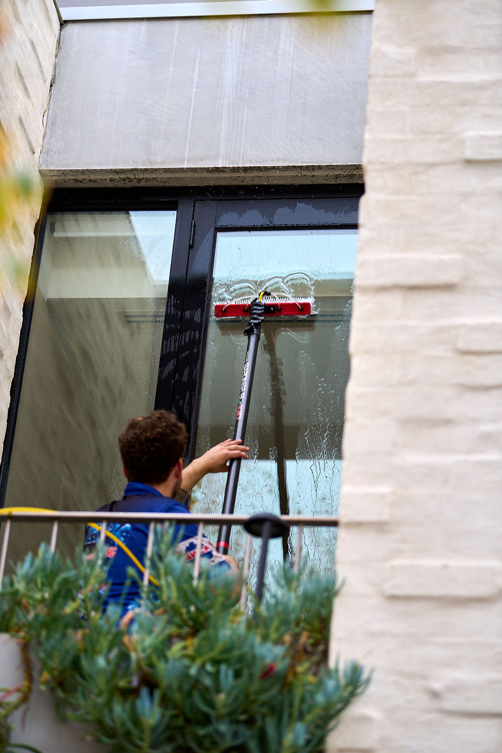Close-up view of a water-fed pole cleaning house windows