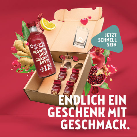 Kloster Kitchen Valentinstag Social Media Ad. Abgebildet ist die Valentinstagsbox mit ihrem Inhalt: 1x 12SHOTS, 4x 1SHOT, 2x Shotgläser. Die Kiste fliegt samt Inhalt vor dem Hintergrund, der einen roten beerigen Ton hat. Die Zutaten fliegen hinter der Box. Headline "Endlich ein Geschenk mit Geschmack.", Störer in Form eines Ingwerstückchen. Störertext: "Jetzt schnell sein"