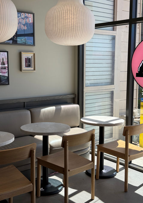 Custom banquette seating with marble café table and modern pendant lighting inside Joe & The Juice.