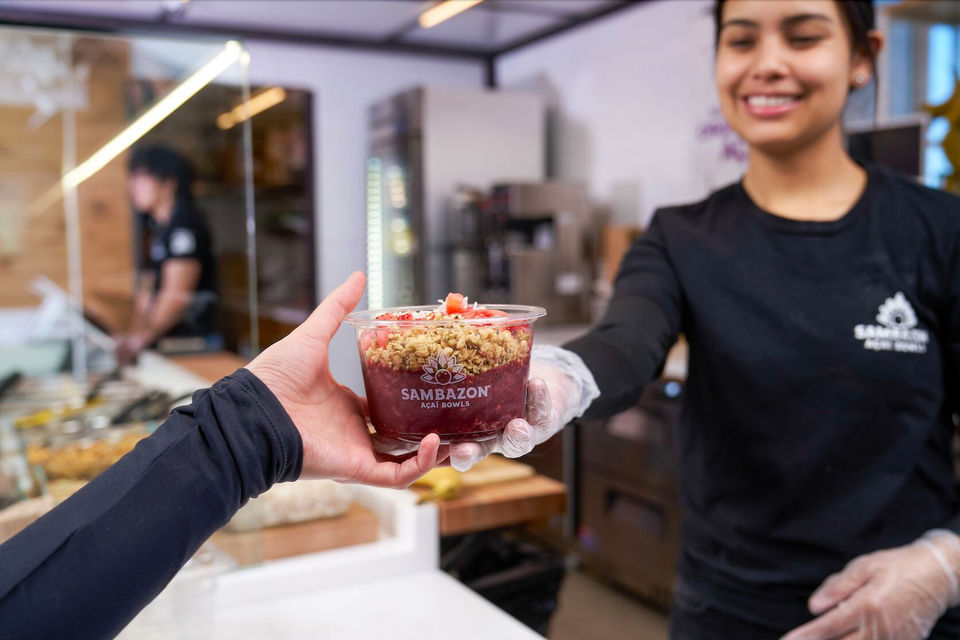 A  worker hands a customer food 