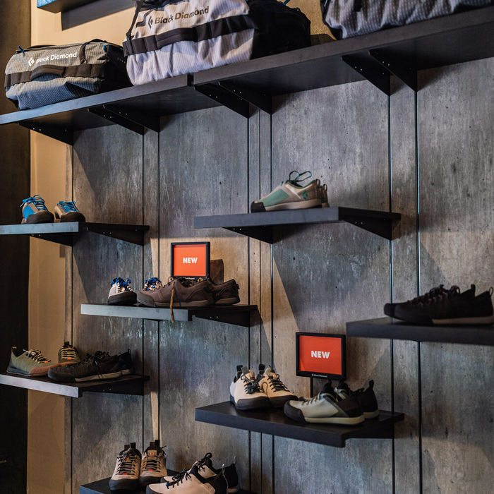 A custom made shoe wall by DisplayIt Inc. featuring shoes and bags on small shelving units.