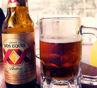 A bottle and a glass of Dos Equis Amber