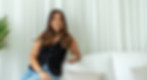 Social media expert Hannah seated casually on a white sofa at the Grid Socials studio