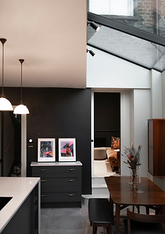 Open kitchen area featuring a wooden dining table in the corner and hanging lamps on the ceiling.