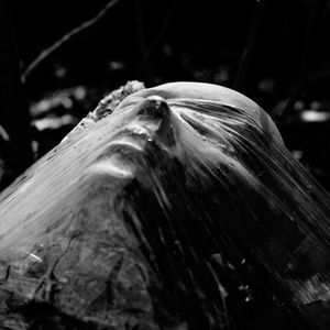a black and white photo of a statue wrapped in plastic