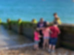 Beach image with Anya showing children the life on the wooden groynes