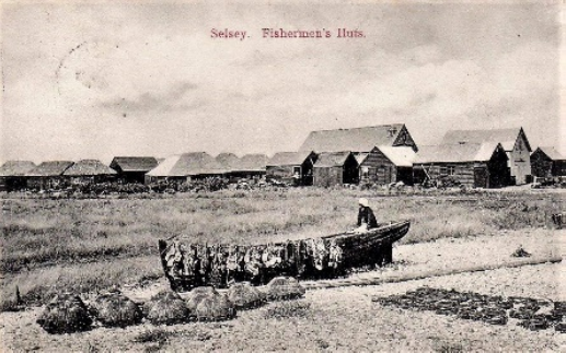 Black and Image of a Early postcard showing a fisherman and his boat