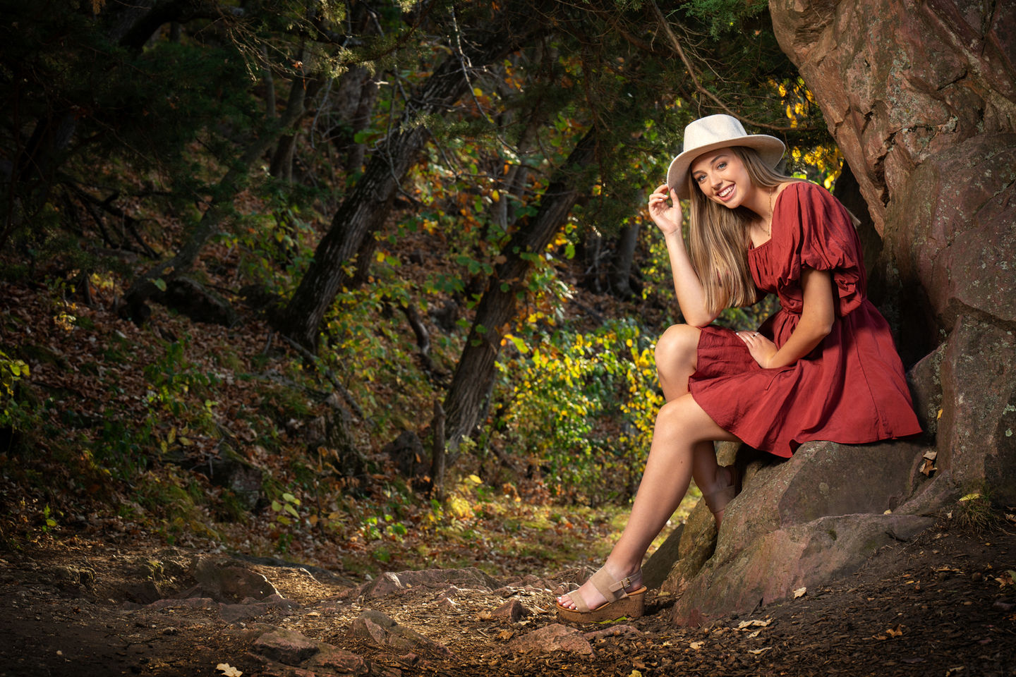 senior girl in a beautiful red dress with a white hat at Palisades State Park near Garretson, SD.  Senior Session.