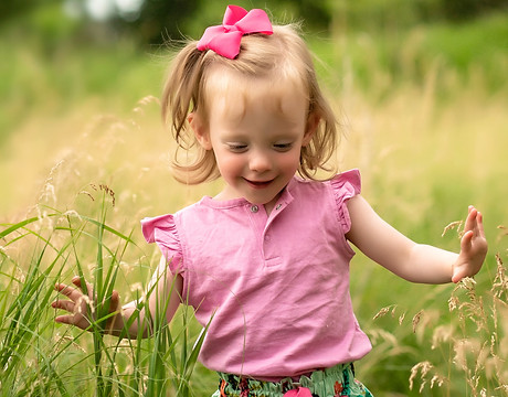 a little girl runs through the tall grass for a family photo shoot in Sioux Falls, SD