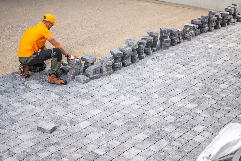 Worker laying pavement blocks