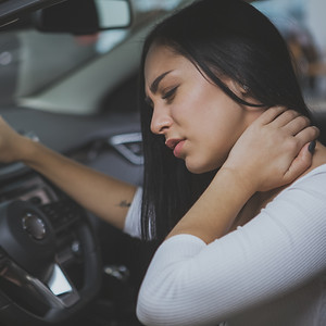 Female driver having terrible neck pain after whiplash injury in car crash