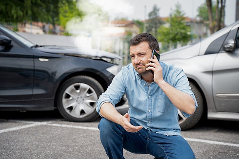 Man reporting car crash damage calling insurance roadside service