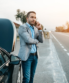 Elegant middle age business man calling towing service for help on the road