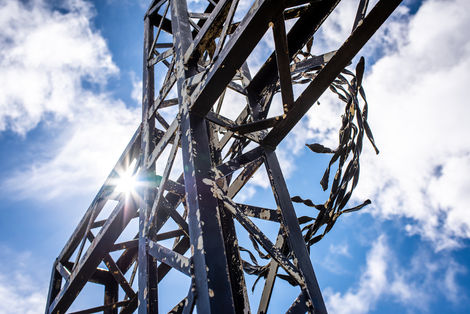 Fotoaufnahme eines Gipfelkreuzes in Südtirol bei Gegenlicht. 