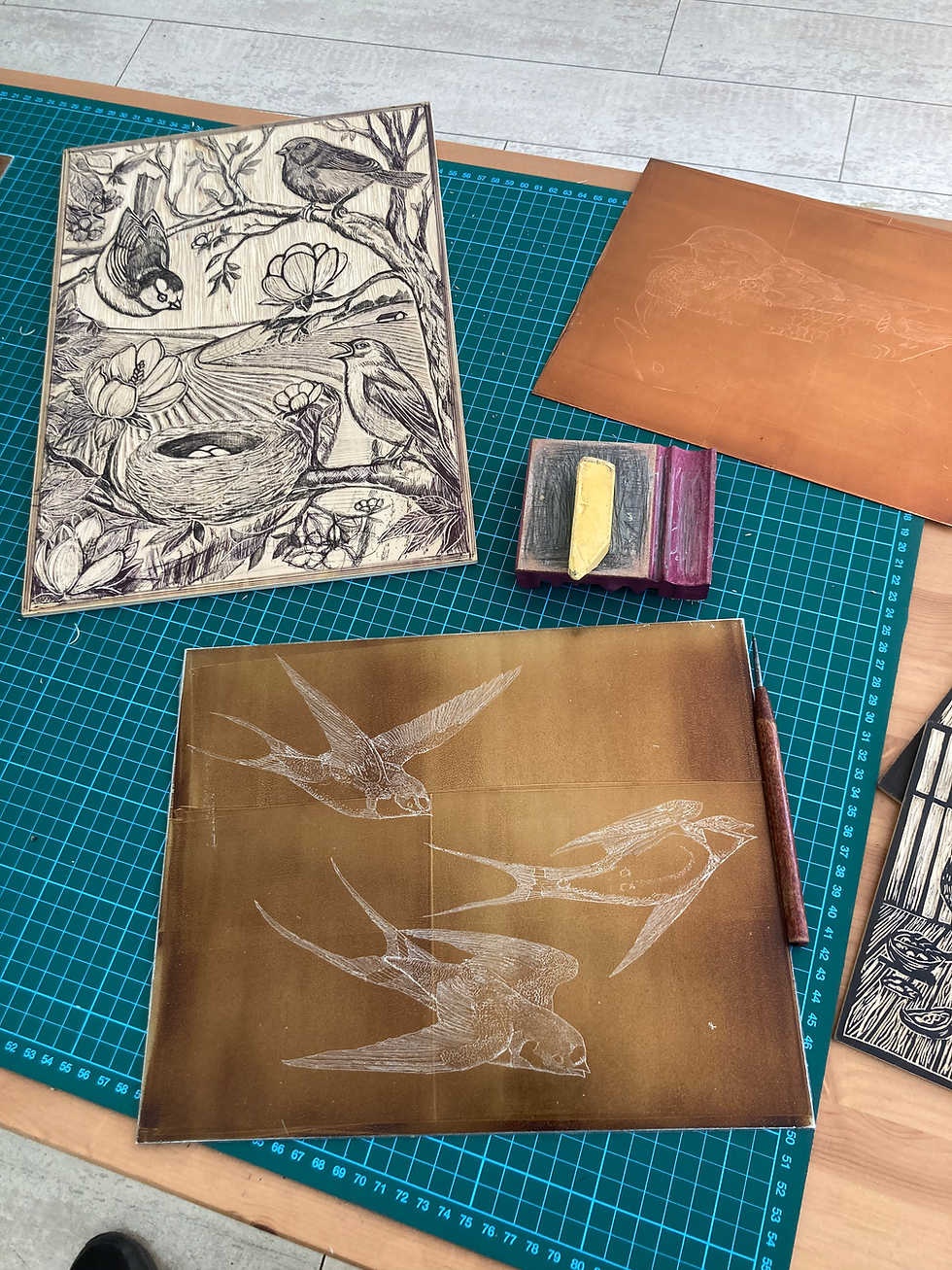 A woodcut plate of a pastoral scene with fields, British birds and a nest; some sharpening stones; a drawing of swallows in a hard ground covered etching plate and a copper plate with a faint drawing of a duck on it