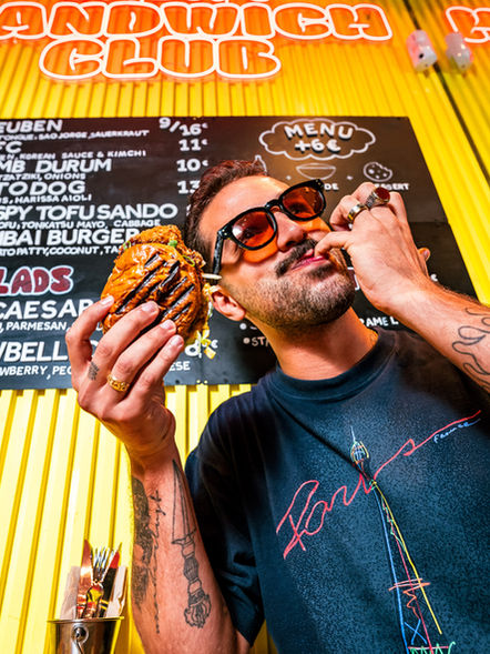 Social media content: man eating a sandwich in Lisbon Sandwich Club.