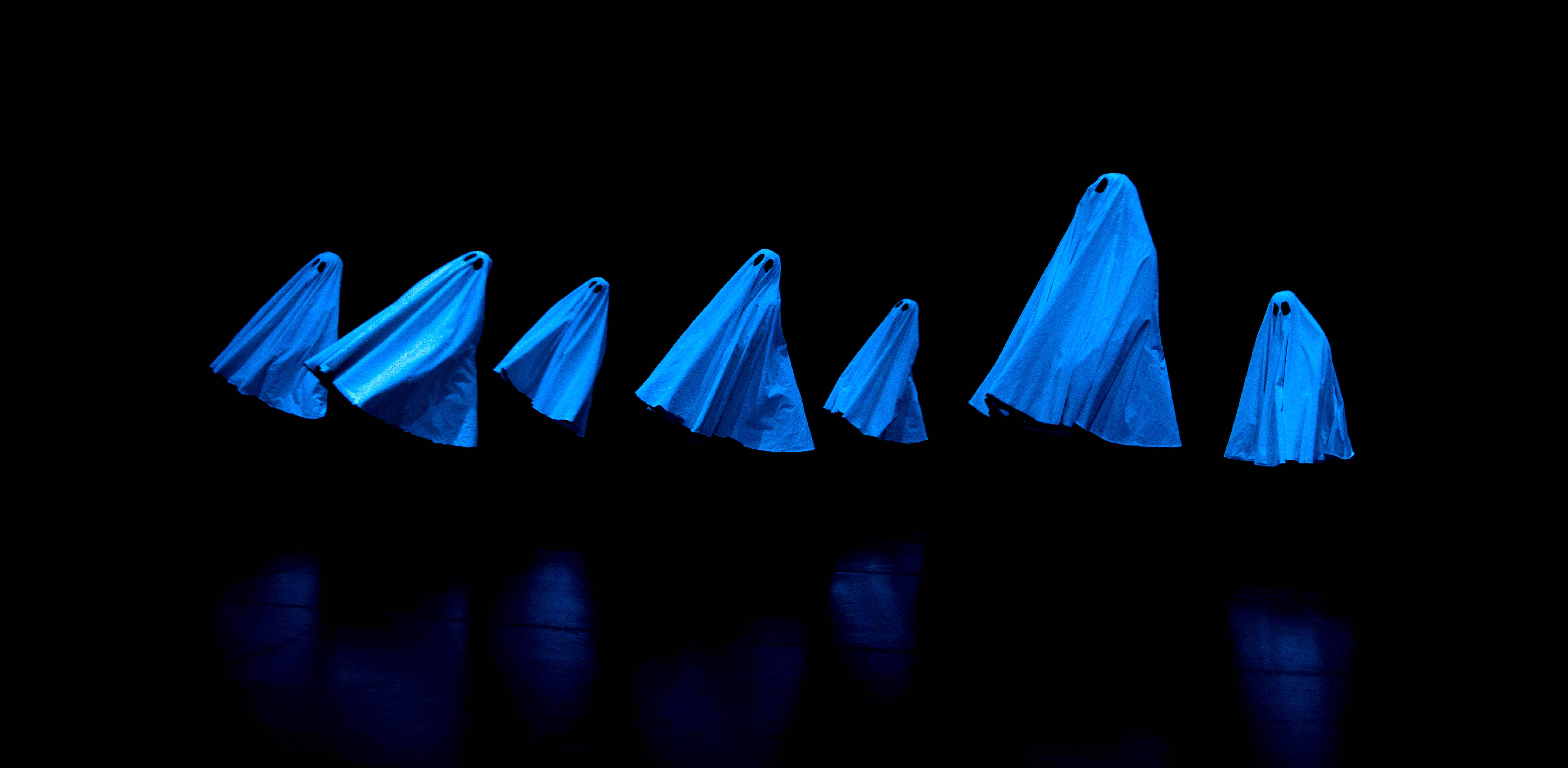 Les sept fantômes bleus de Pillowgraphies sur une scène noire