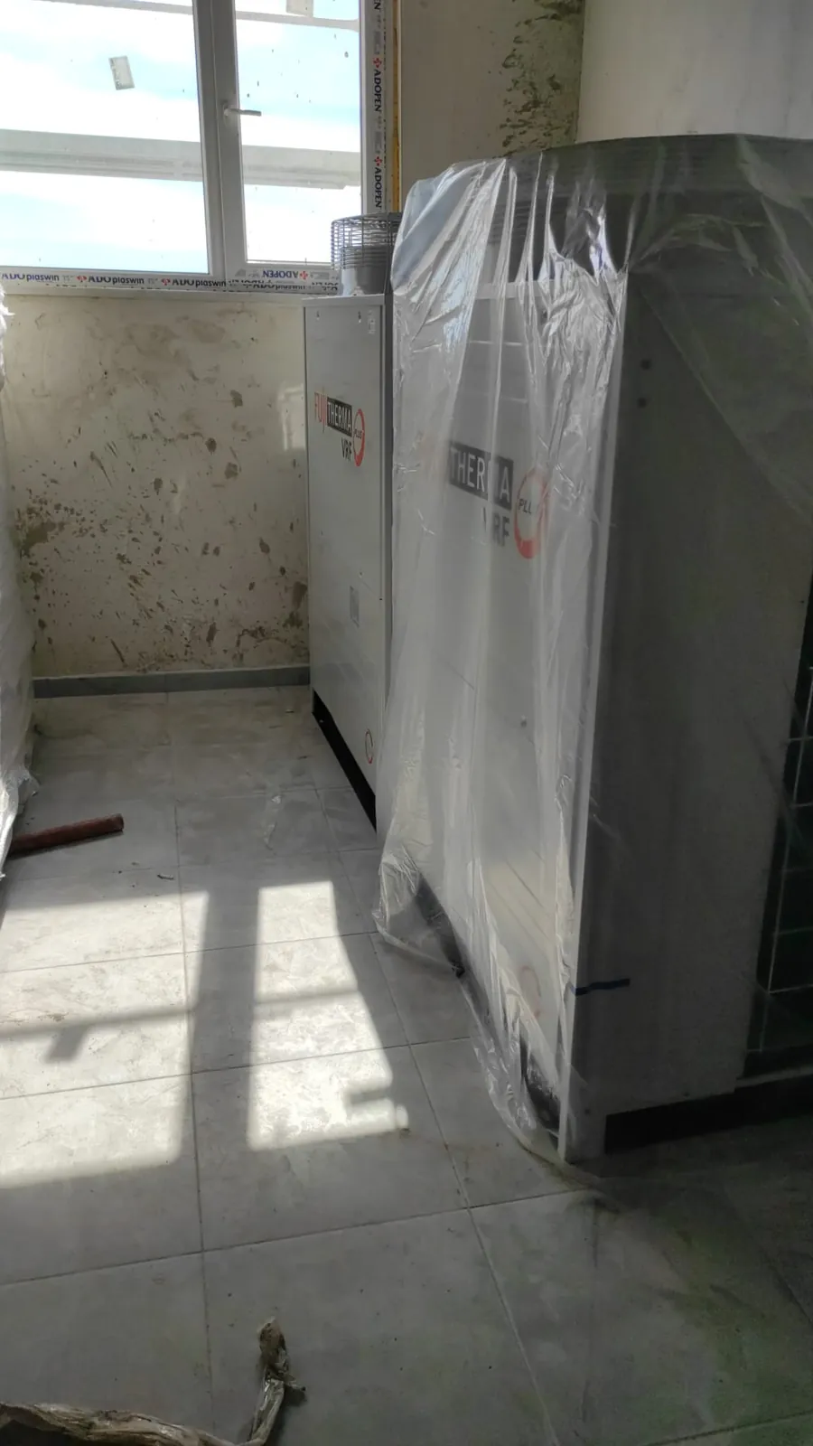 Pencereli teknik alanda naylonla korunan FUJITHERMA VRF dış üniteler ve kaba duvar yüzeyleri