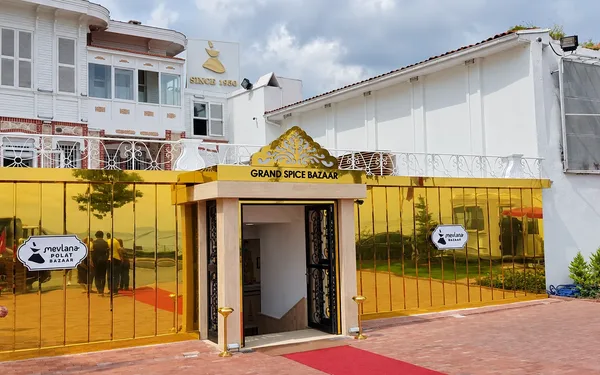 Sultanahmet Bazaar projesindeki altın renkli aynalı mağaza cephesi, giriş kapısı ve üzerindeki Grand Spice Bazaar tabelası.