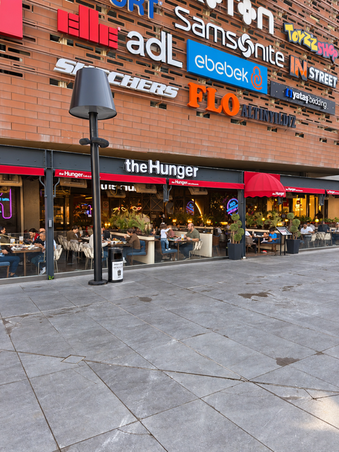 Meydan AVM The Hunger restoranının tabelası, kırmızı tenteleri ve oturma alanı