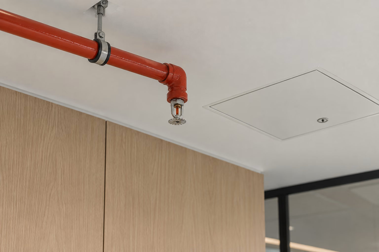 Tavandaki kırmızı yangın borusu ve sprinkler başlığı; temsili görsel.