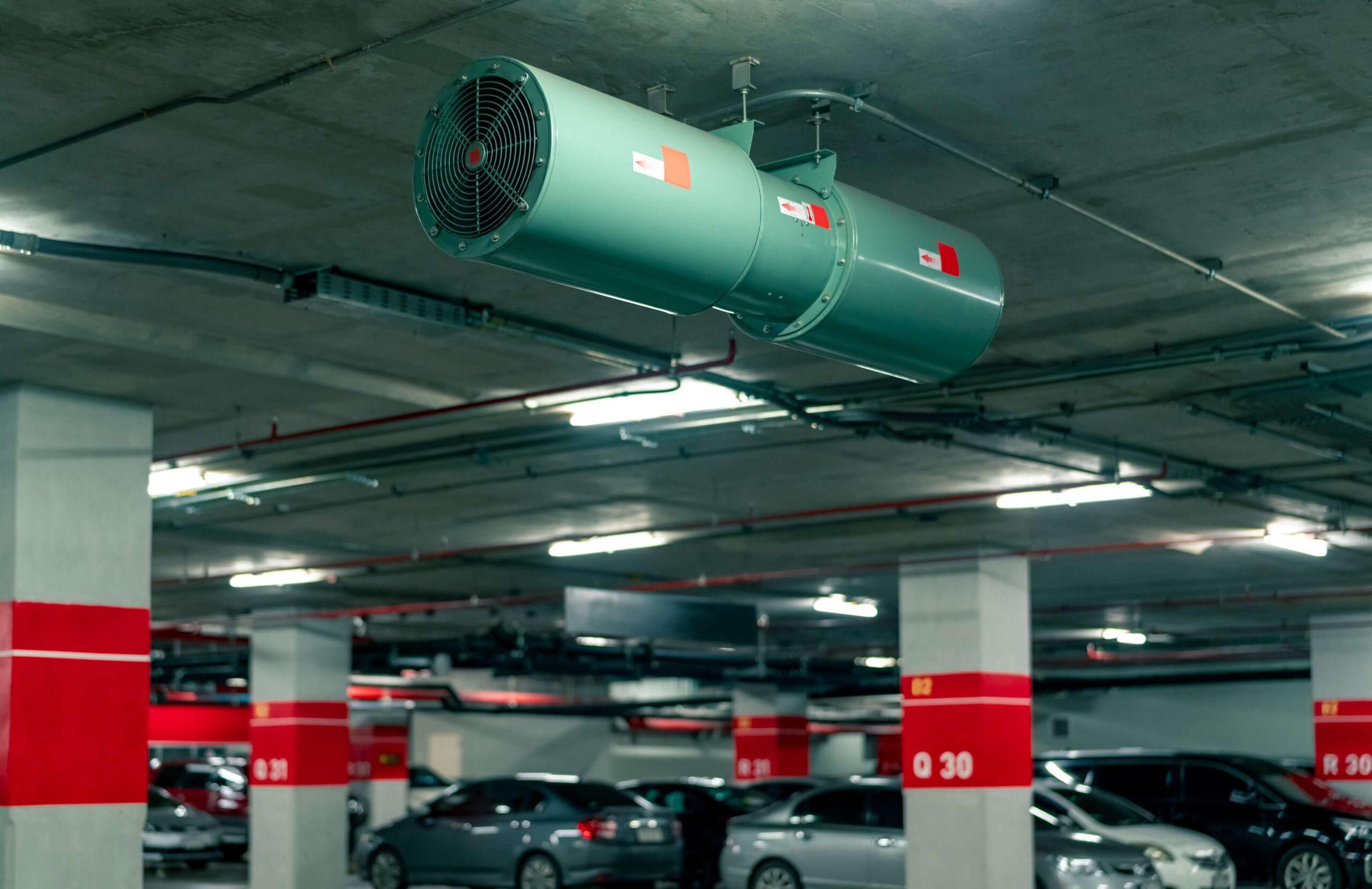 Ceiling-mounted jet fan in an underground car park.