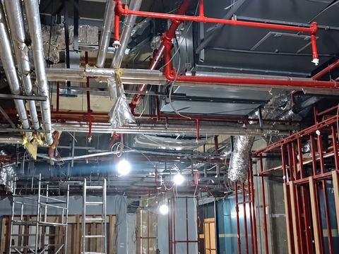 Sprinkler pipes and insulated ventilation ducts above the Mavi store aisle