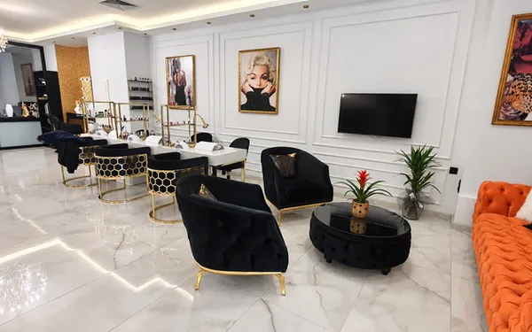 Bakım istasyonları ve siyah, altın ve turuncu mobilyalı salon.