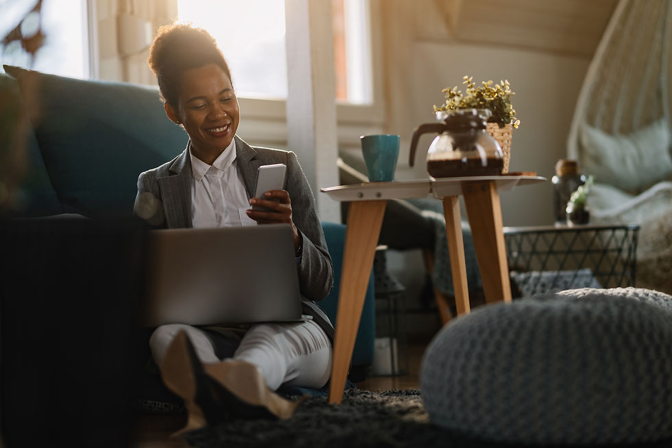 happy-african-american-entrepreneur-reading-text-message-cell-phone-while-working-laptop-h